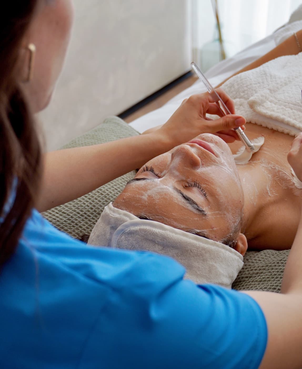 Aplicación de mascarilla facial sobre la piel con brocha